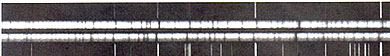 Spectra (two inner strips) from a binary star pair; this rendition is that of a photo-negative in which the spectral lines are printed as white.